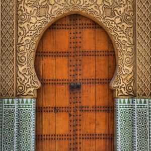 Porte marocaine sculptée à la feuille dorée encadrée de zelliges