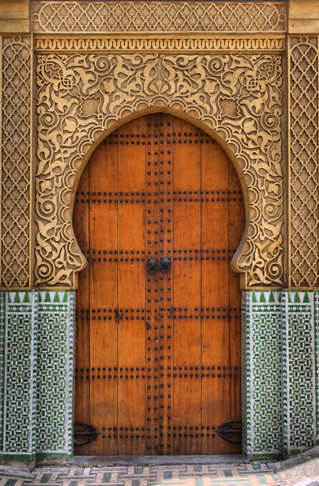 Porte marocaine sculptée à la feuille dorée encadrée de zelliges