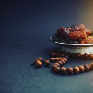 Dattes et chapelet en bois sur fond sombre, symboles du Ramadan